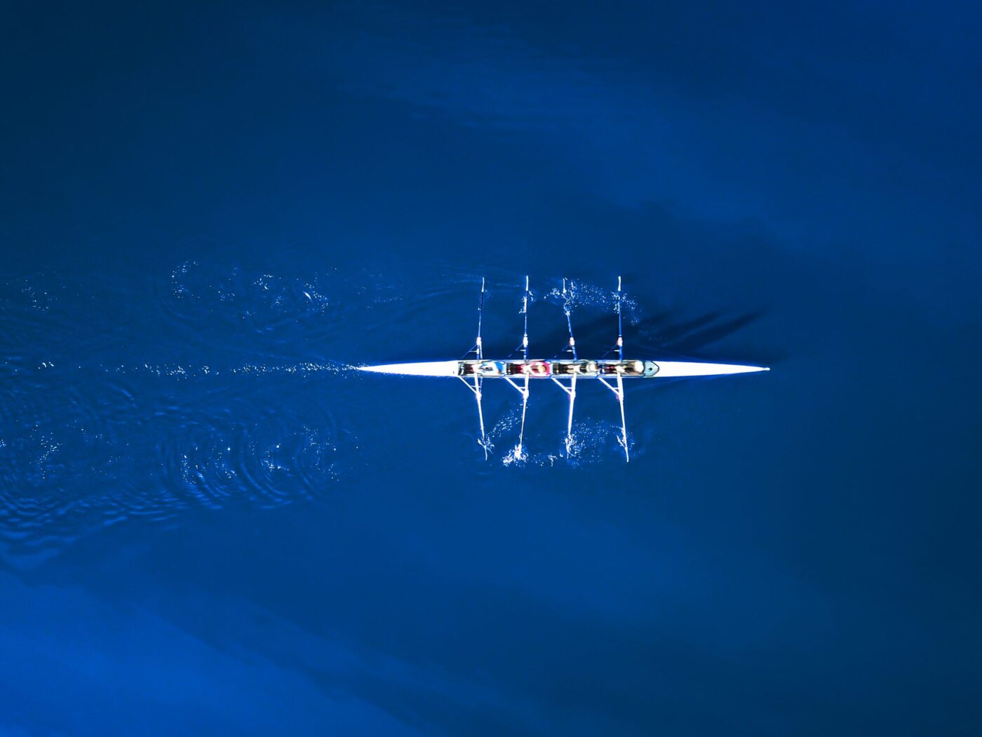 Aerial View Of A Rowing Boat Surrounded By Classic Blue Water