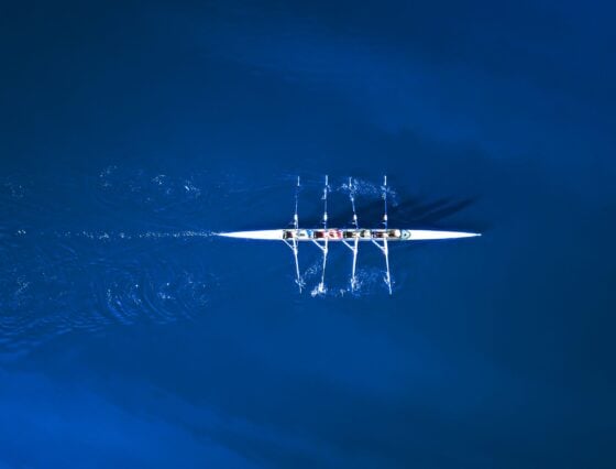 Aerial View Of A Rowing Boat Surrounded By Classic Blue Water
